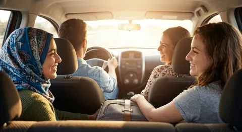 Mitfahrende lachen gemeinsam im Auto